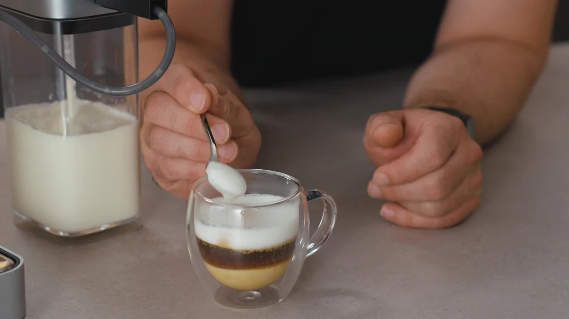Der Milchschaum gelingt feinporig und cremig - hier per Löffelprobe geprüft.