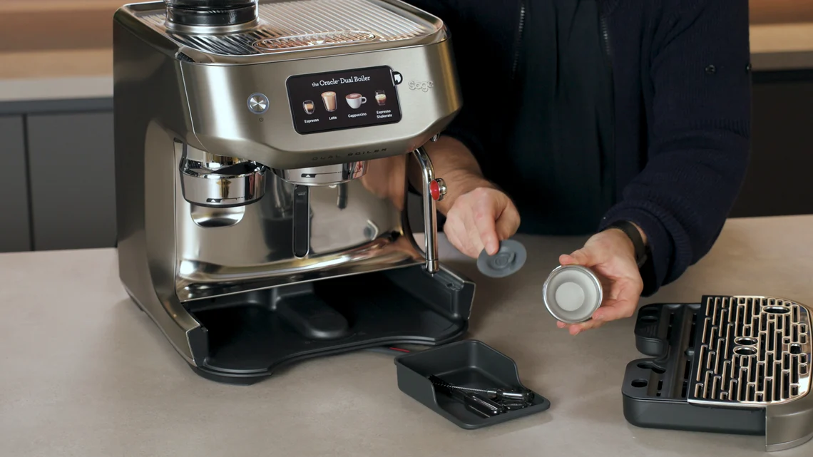 Praktisch: Das mitgelieferte Reinigungszubehör lässt sich in einem kleinen Fach hinter der Tropfschale verstauen.